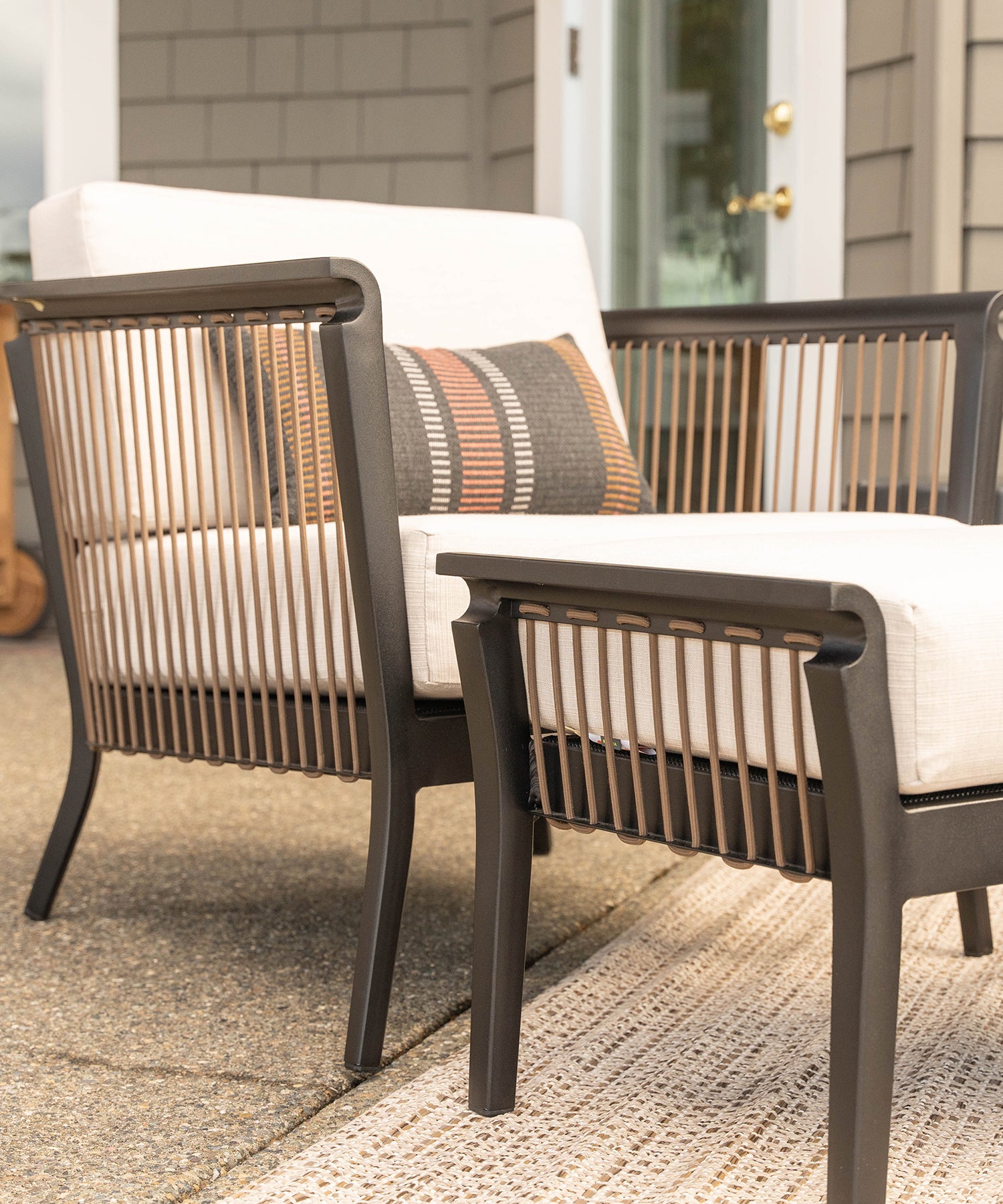 Close-up of outdoor rope and aluminum chair and ottoman with white cushions